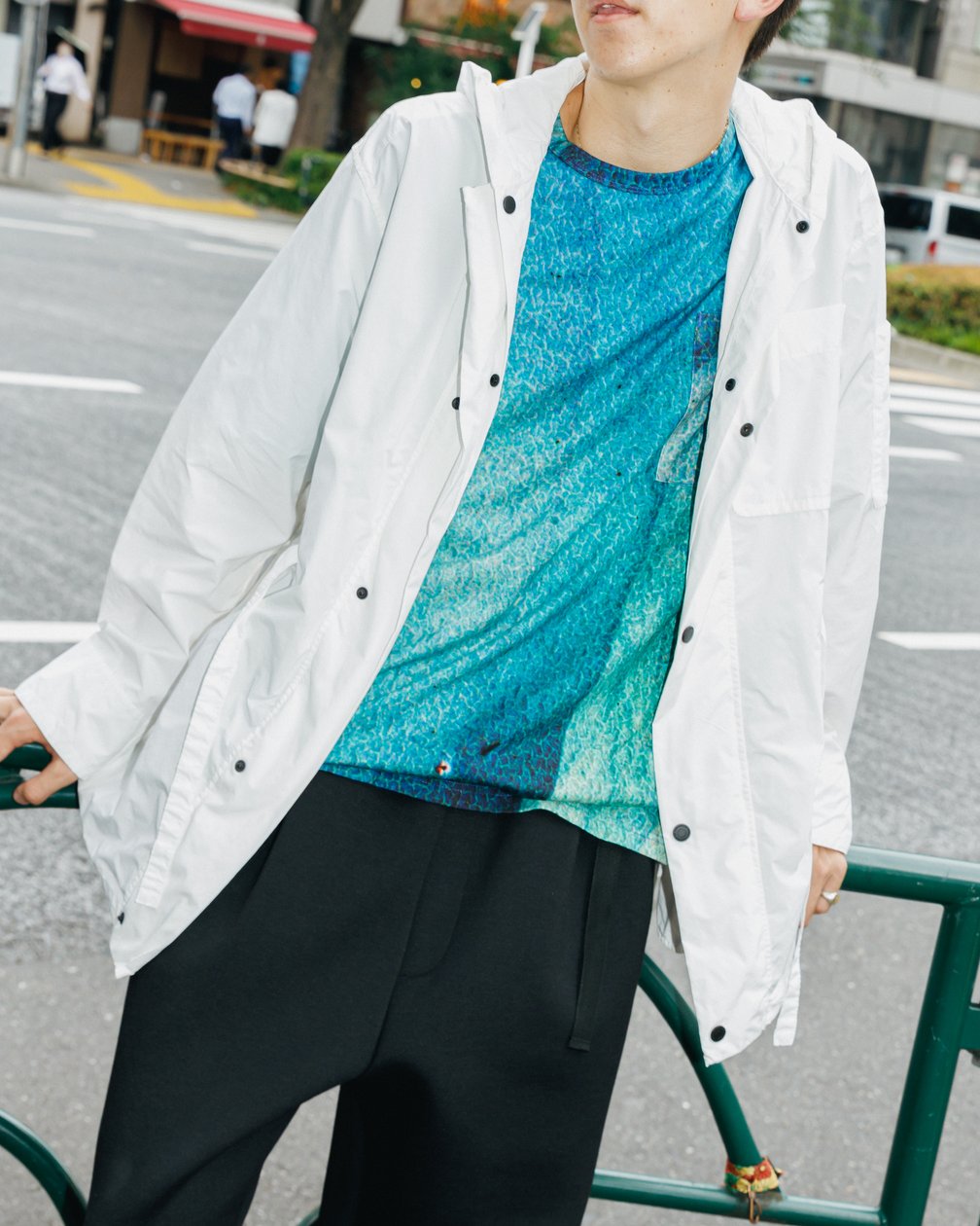 ブルーのTシャツに白のブルゾンを羽織った男性モデル