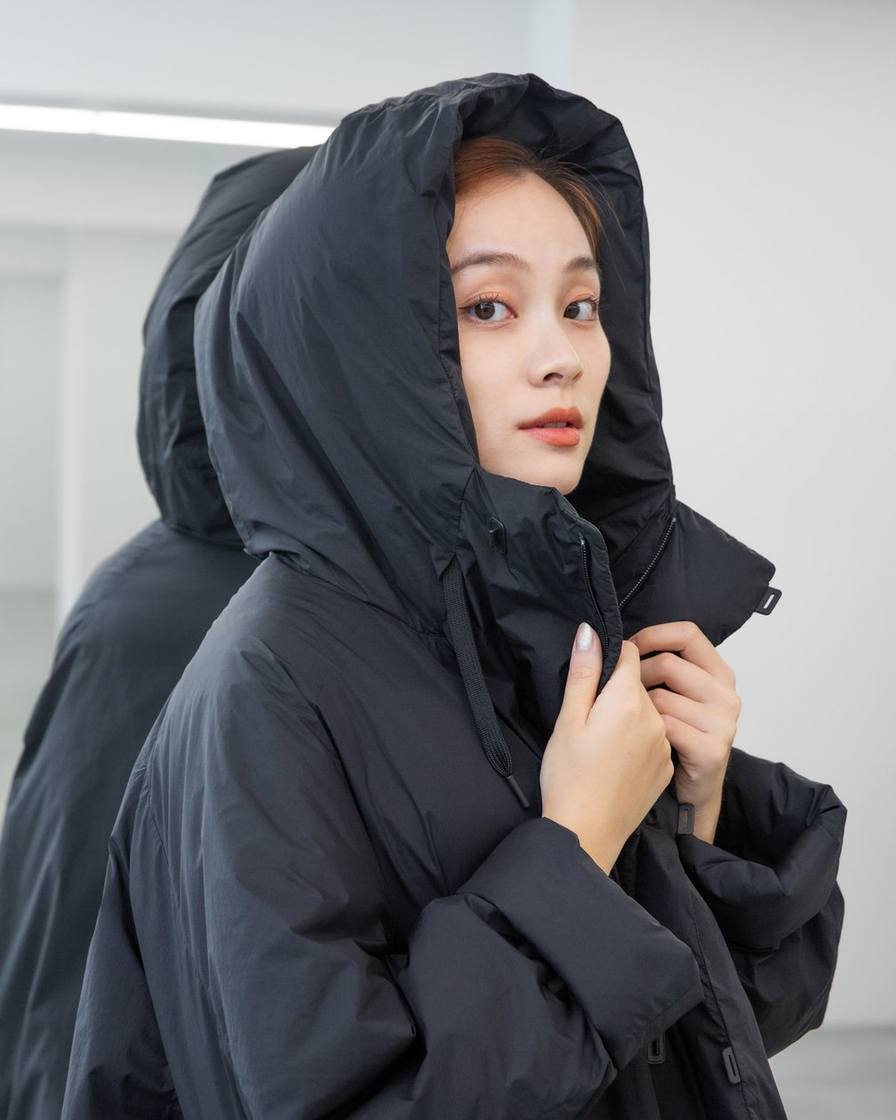 フードをかぶった女性モデル