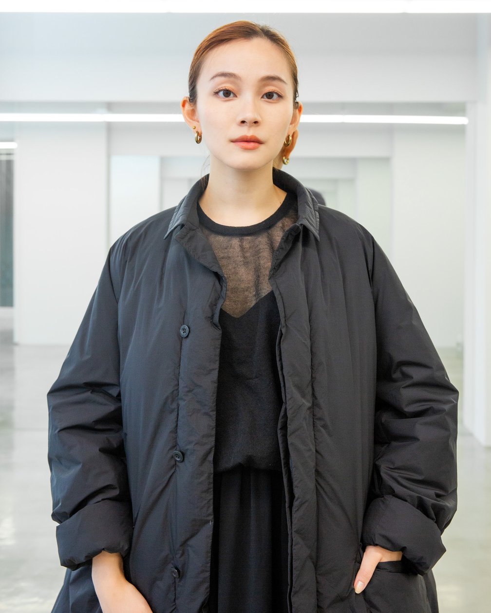 テアトラのダウン「タイムアダプター」を着用した女性モデル