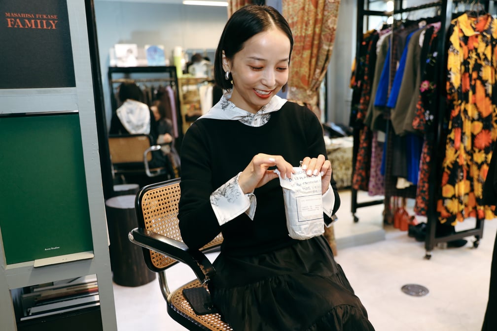 ハーブティーの袋を持って椅子に座る長尾悠美