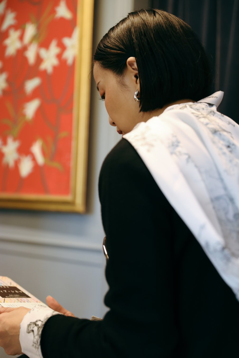 本を手に持つ長尾悠美の後ろ姿