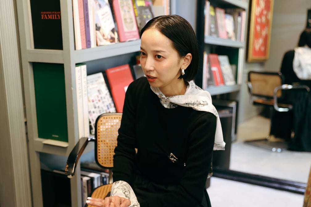 椅子に座った黒い服を着た長尾悠美