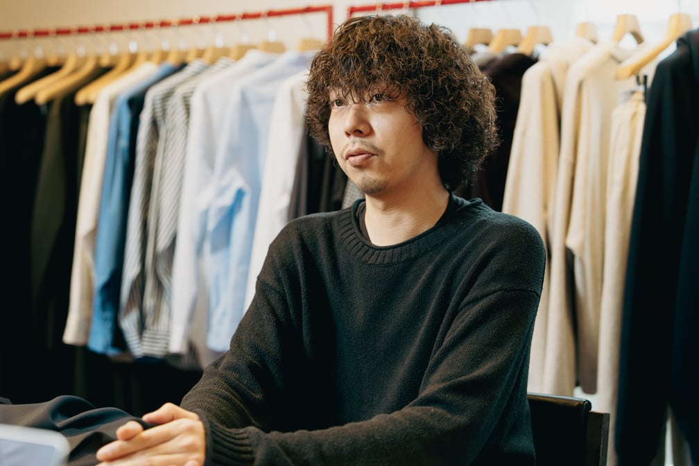 話すバイヤーの中根