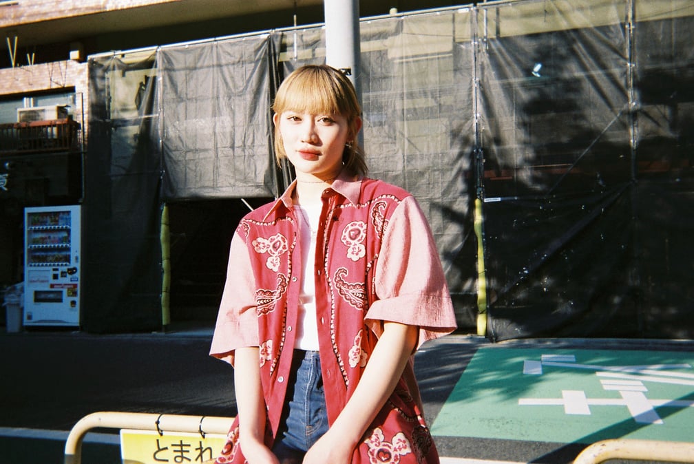 公園の柵に座る佐々木莉佳子