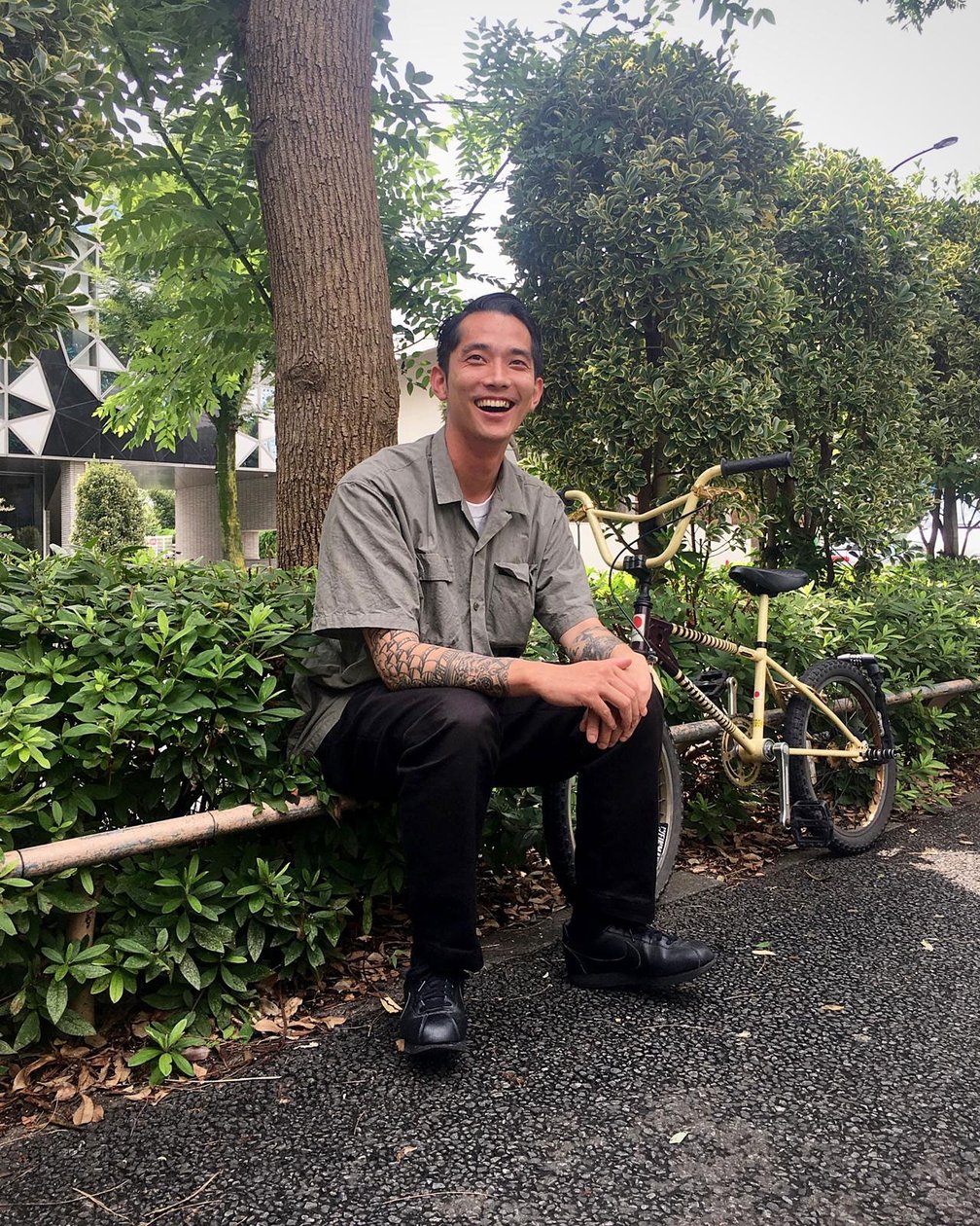 街路樹の前に座る山本海人氏