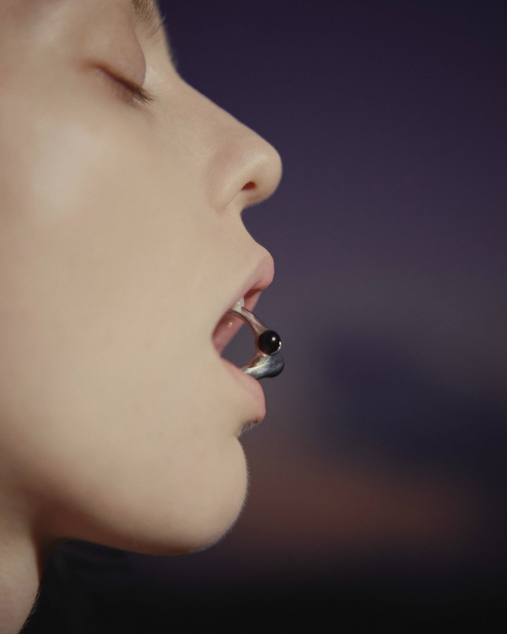 アクセサリーを噛む女性モデル