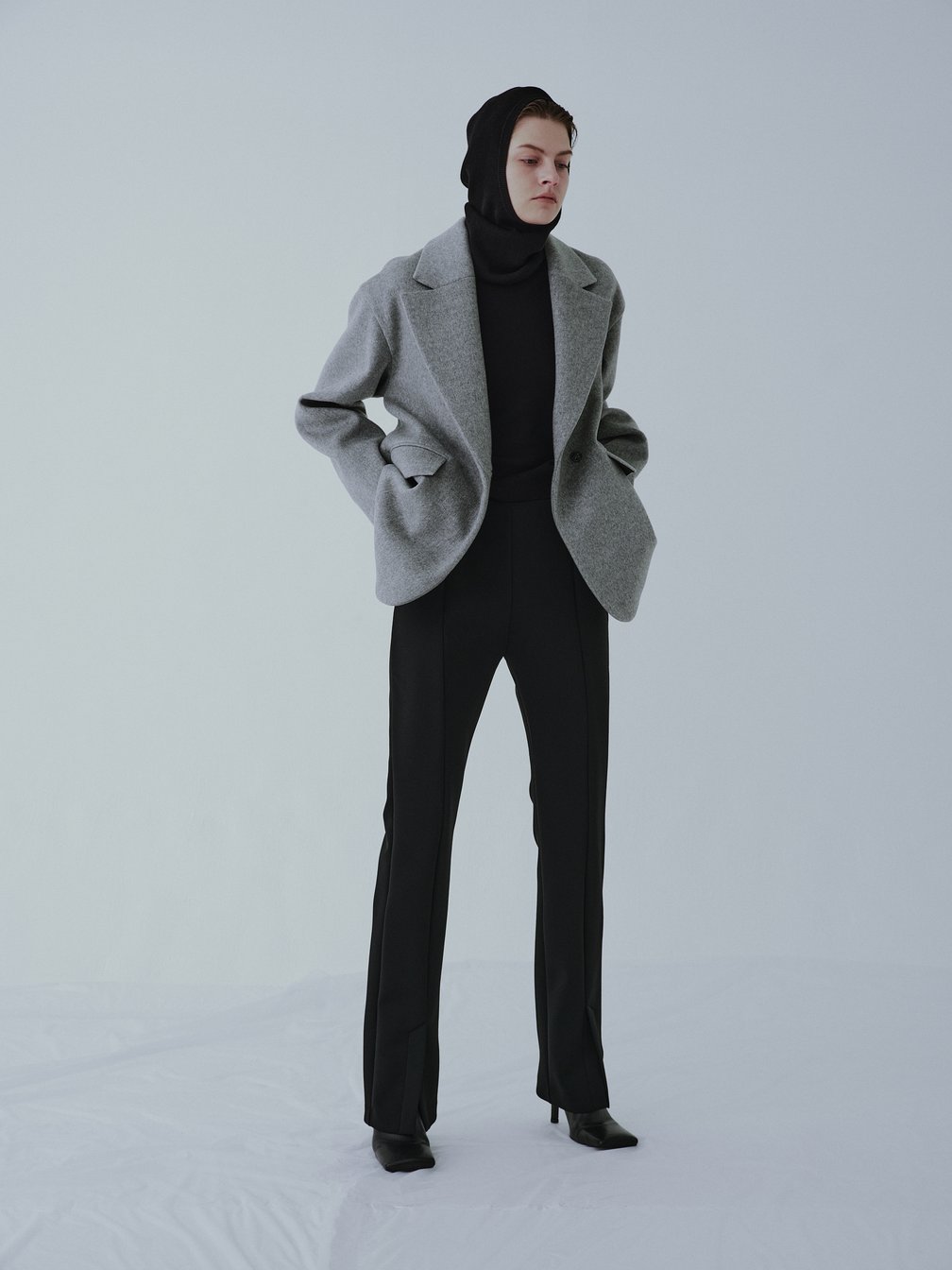 グレーのジャケットを纏う女性モデル