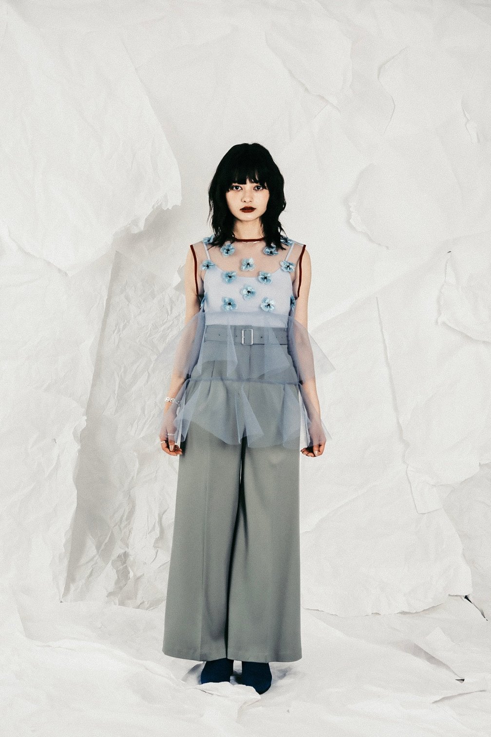 ハードチュールに花柄の刺繍をあしらった立体的なコルセットトップスに、モスグリーンのパンツと合わせた女性モデル