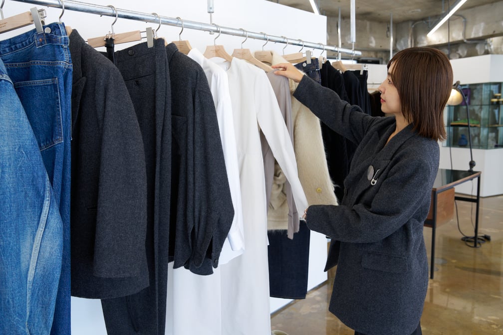 ラックの洋服を直す女性