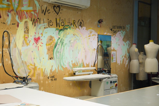 さまざまな落書きがされているファッション学校の教室の壁