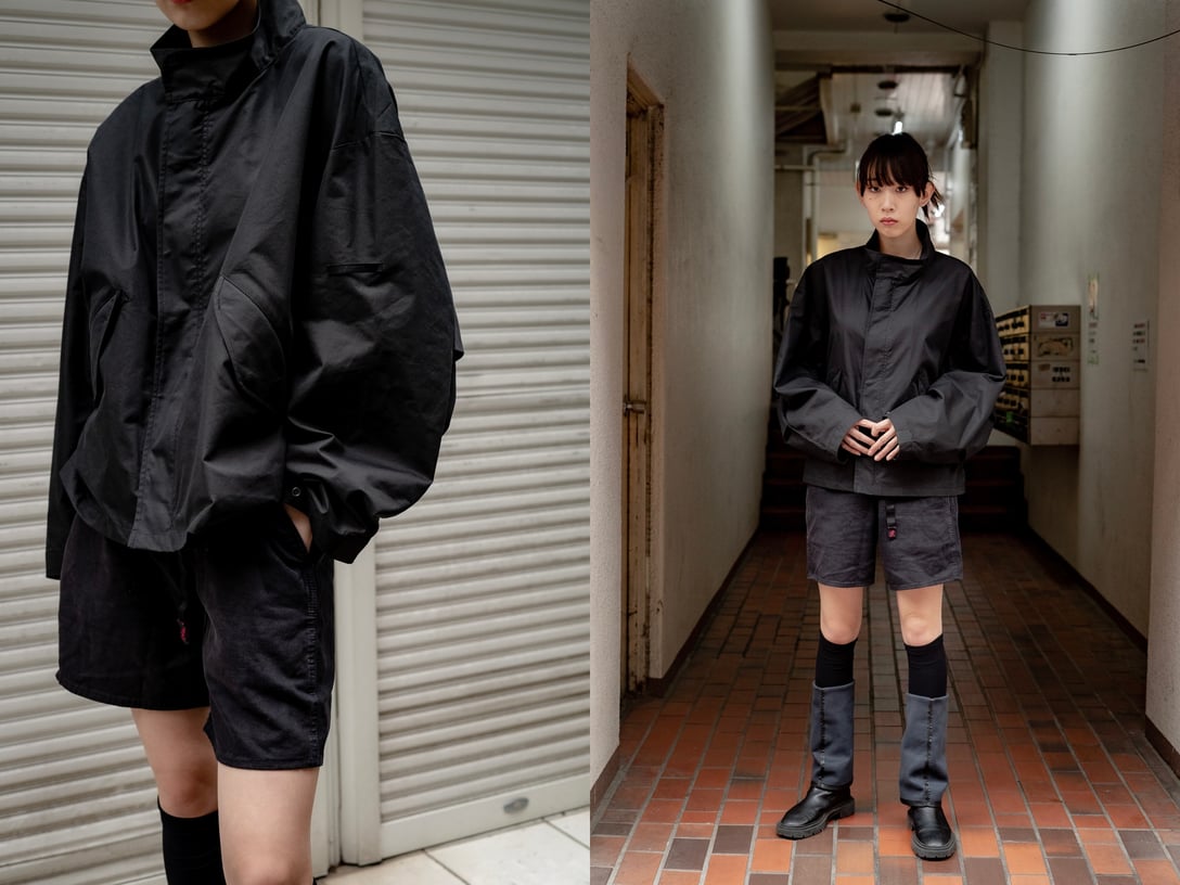 黒のナイロンジャケットとショートパンツを着用した女性モデル