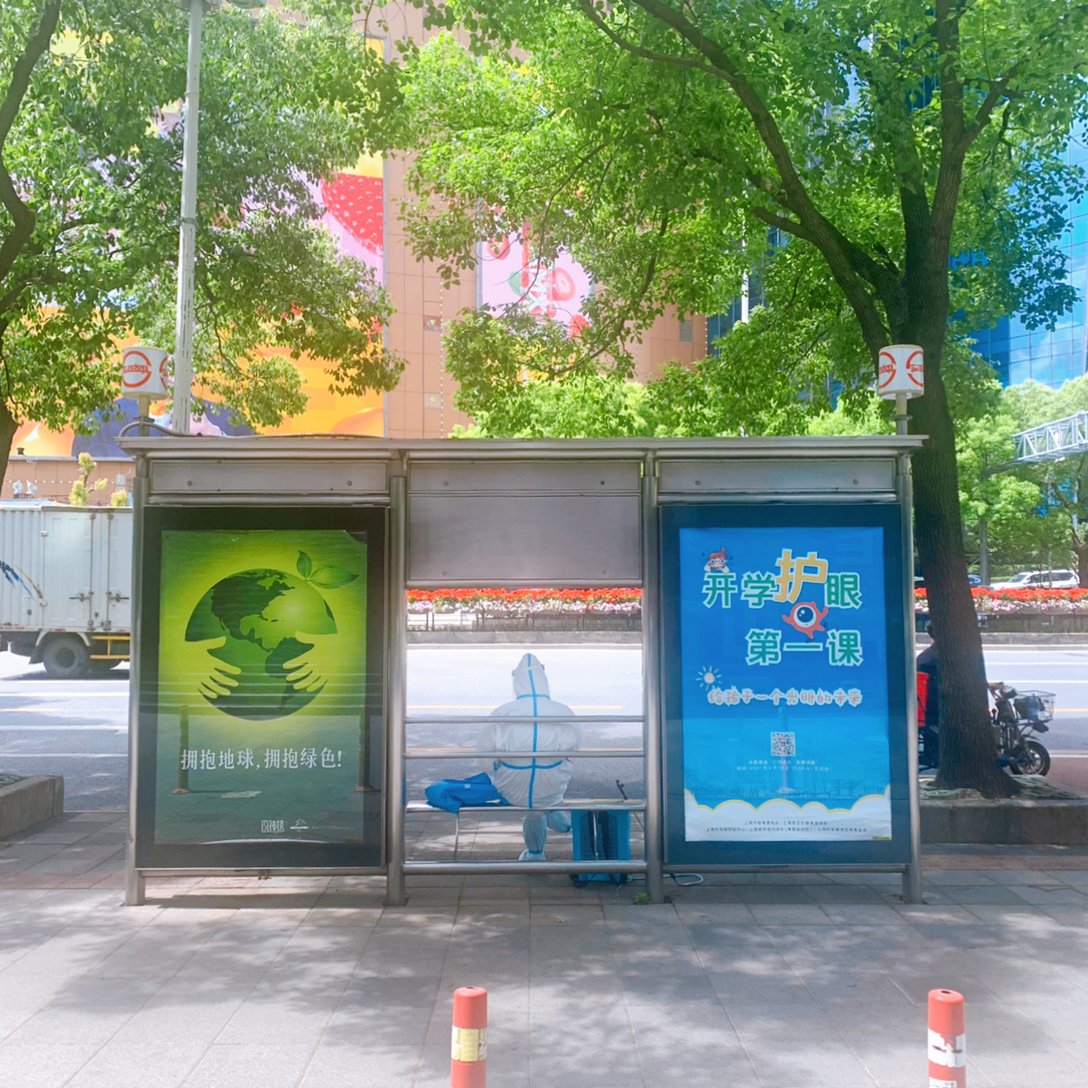 上海のバス停で休憩するPCR検査のスタッフ