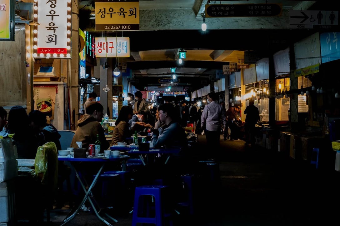 ソウルで屈指の歴史と規模を誇る広蔵市場で、ソジュや生肉料理のユッケを楽しむ韓国人たち。4月29日。PHOTO: YUNBEOM BAE