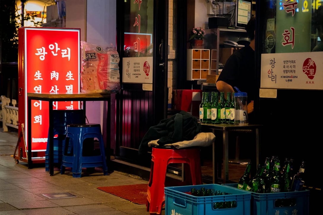 ソウル、鐘路のポジャンマチャ通りの飲食店の前に集められたソジュの緑色の空き瓶。4月29日。PHOTO: YUNBEOM BAE