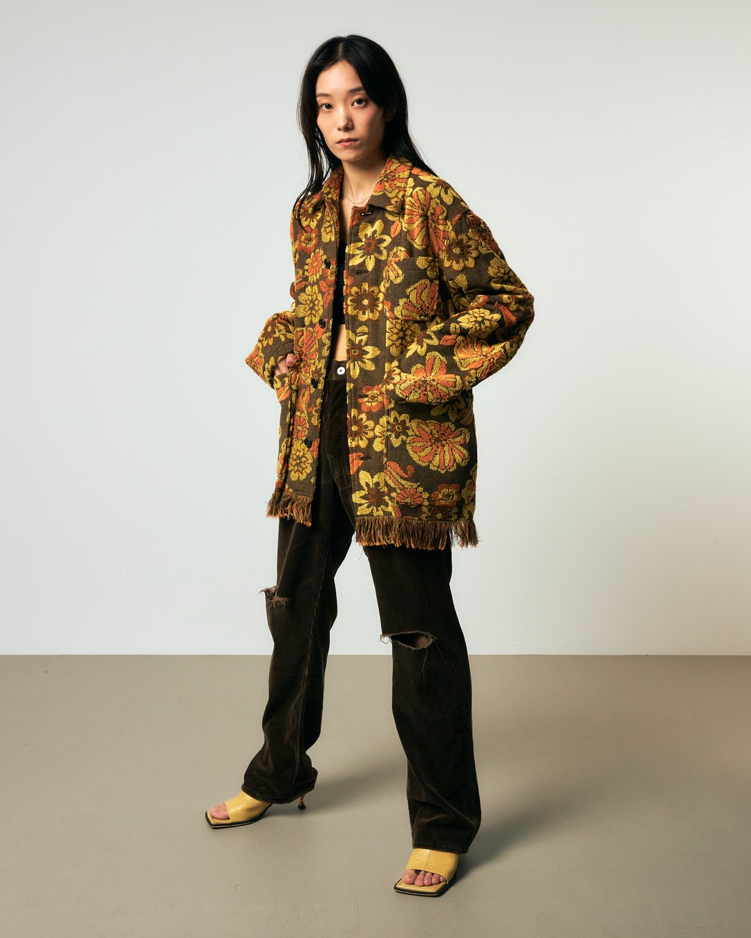 花柄のパイルジャケットにカーキのパンツを合わせた女性モデル