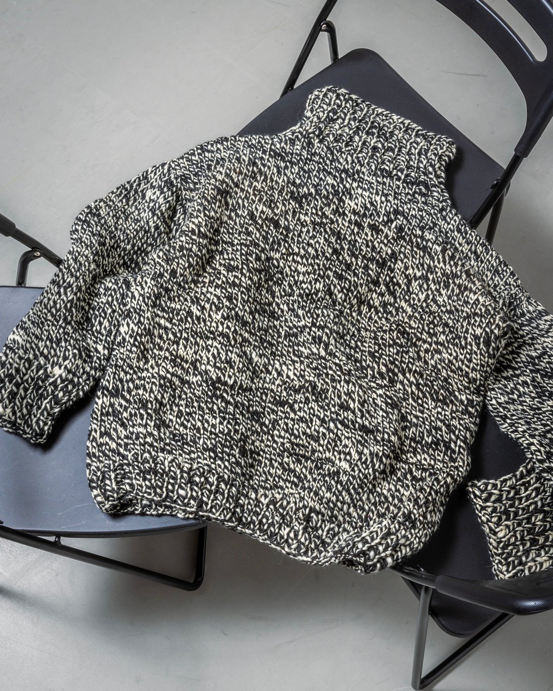 椅子に置かれたシーオールのハイネックセーター