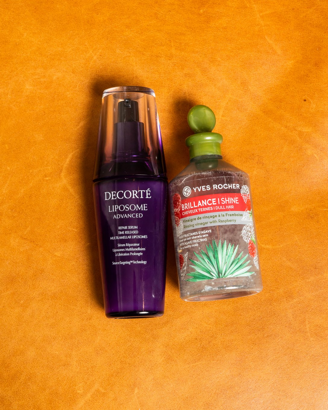紫のパッケージの美容液と透明パッケージの化粧品