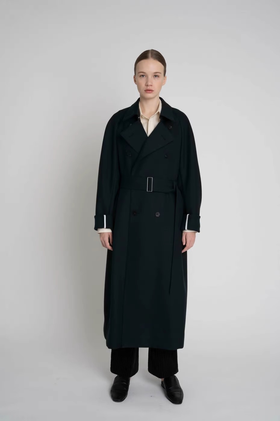 オーバーコートのラグランスリーブオーバーコートを着た女性モデル