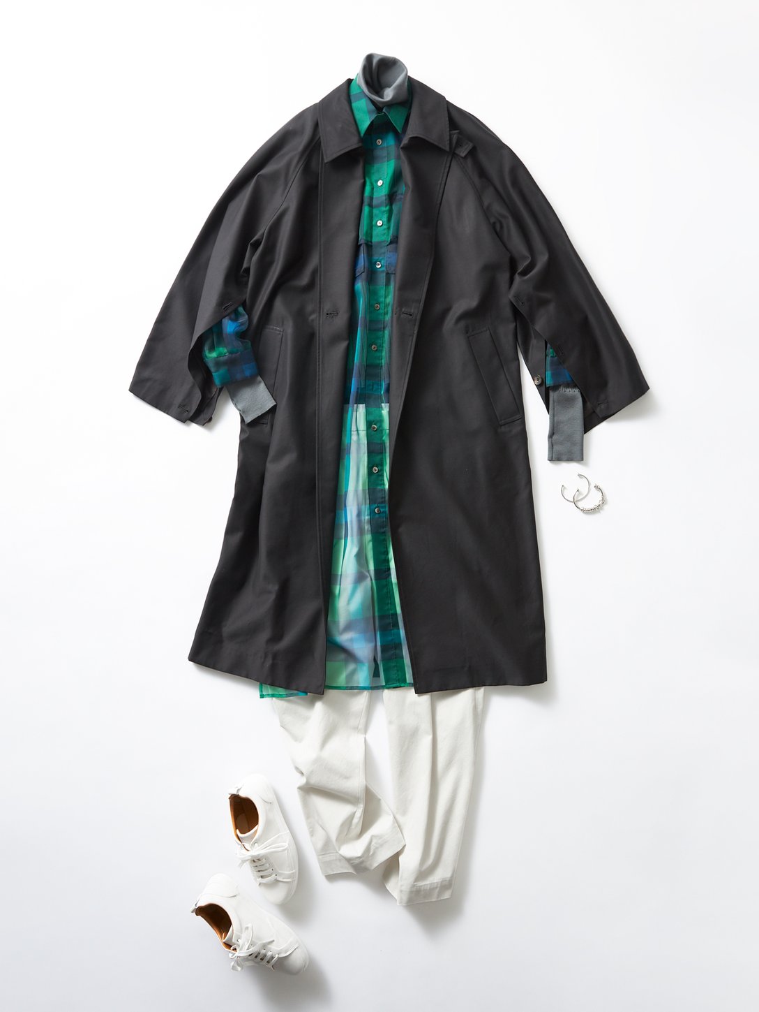黒いコート、グリーンのロングシャツ、白いパンツを合わせたルック