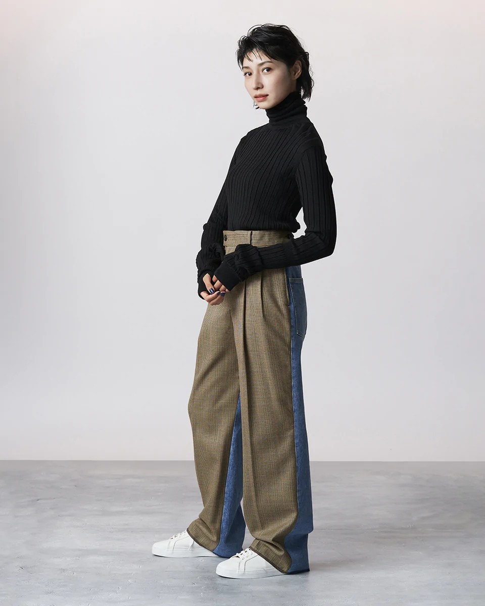 グレンチェックコンビデニムパンツを穿いた女性モデルの横向き写真