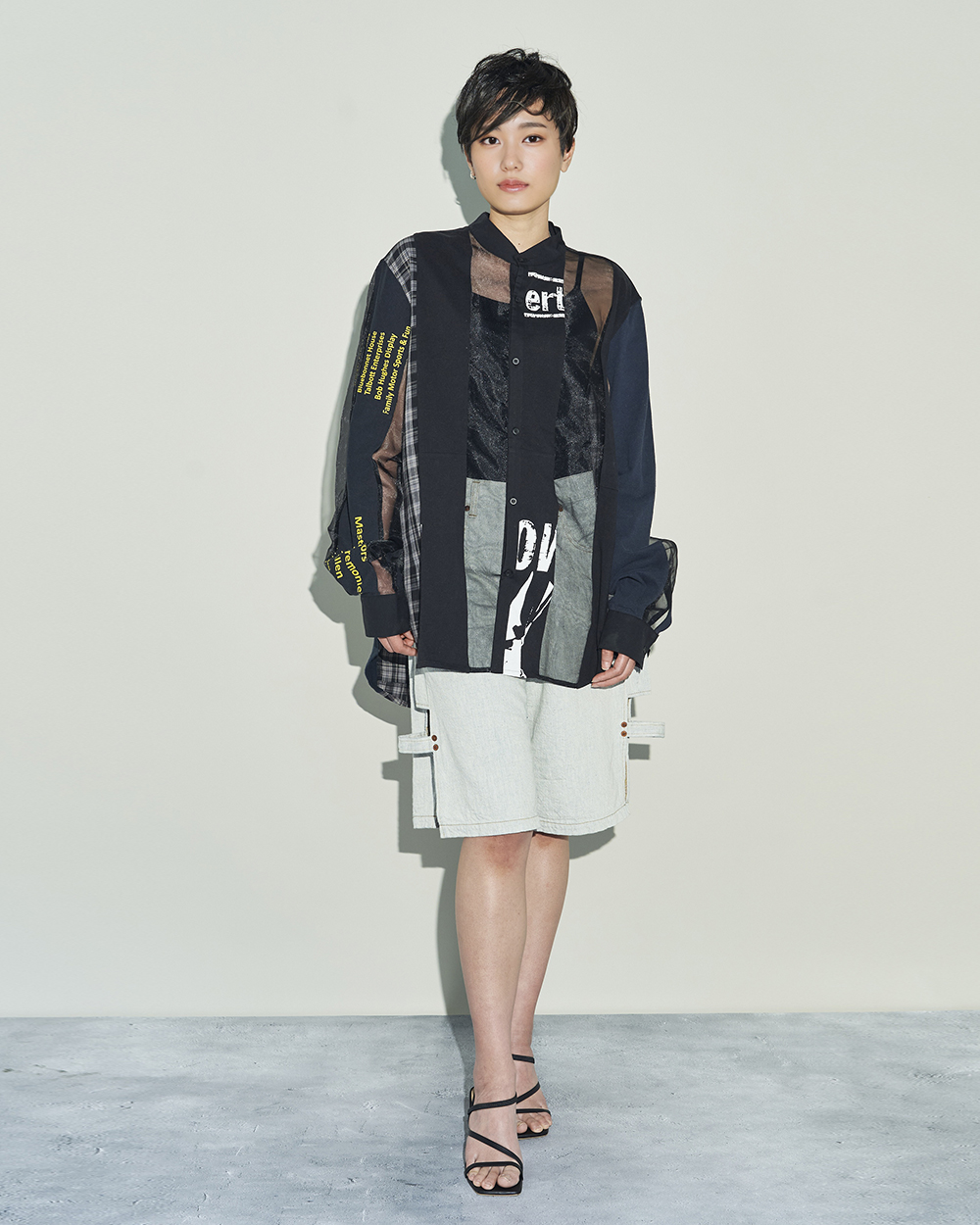 コトハヨコザワのデニムショーツとスリューのリメイクブラウスを着用した女性モデル