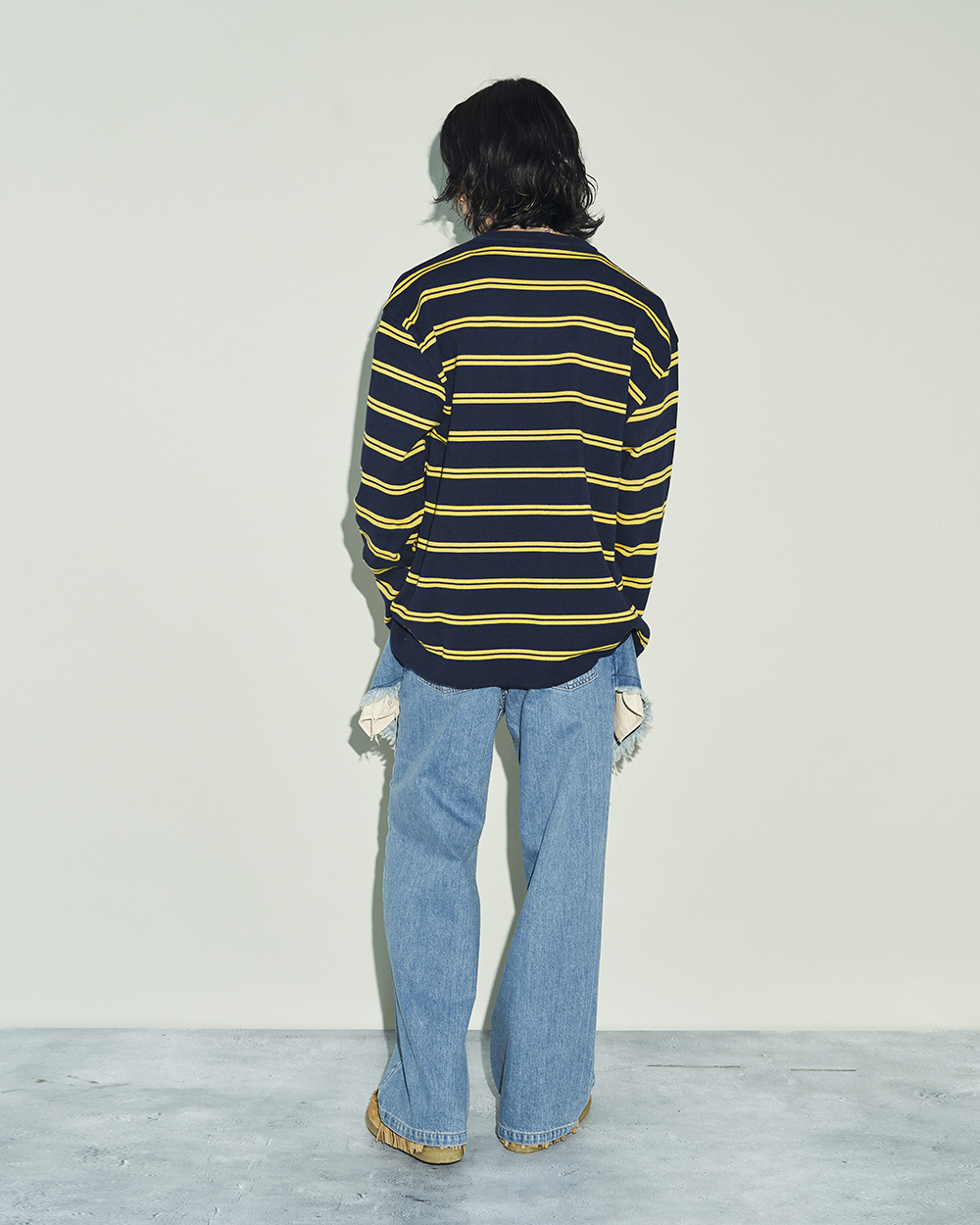 コトハヨコザワのレイヤードデニムパンツを穿いた男性モデル