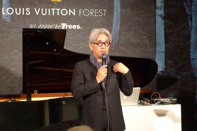 ピアノの前で話す坂本龍一