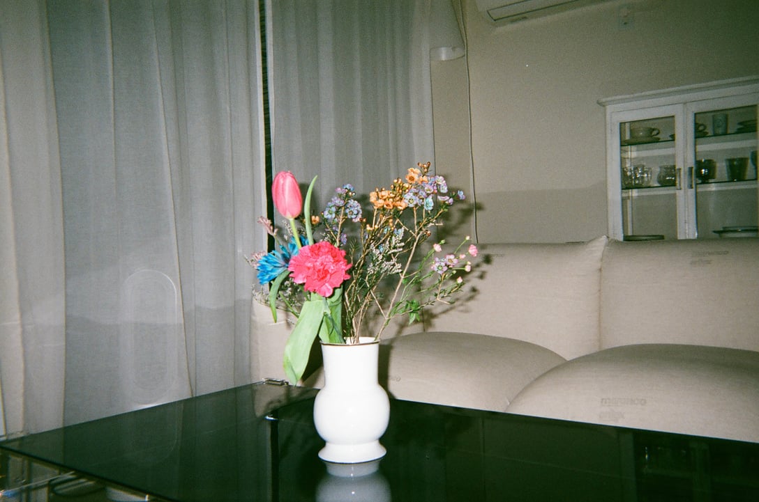 テーブルの上にある花瓶の中に色とりどりの花が生けてある。