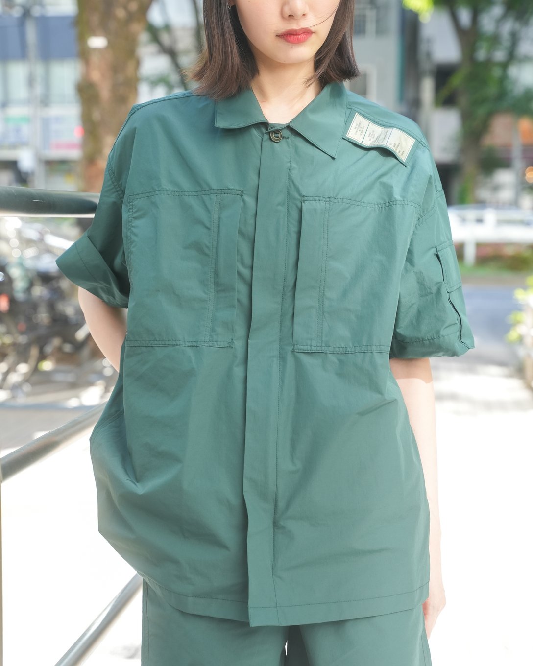 グリーンのセットアップを着用した女性モデル