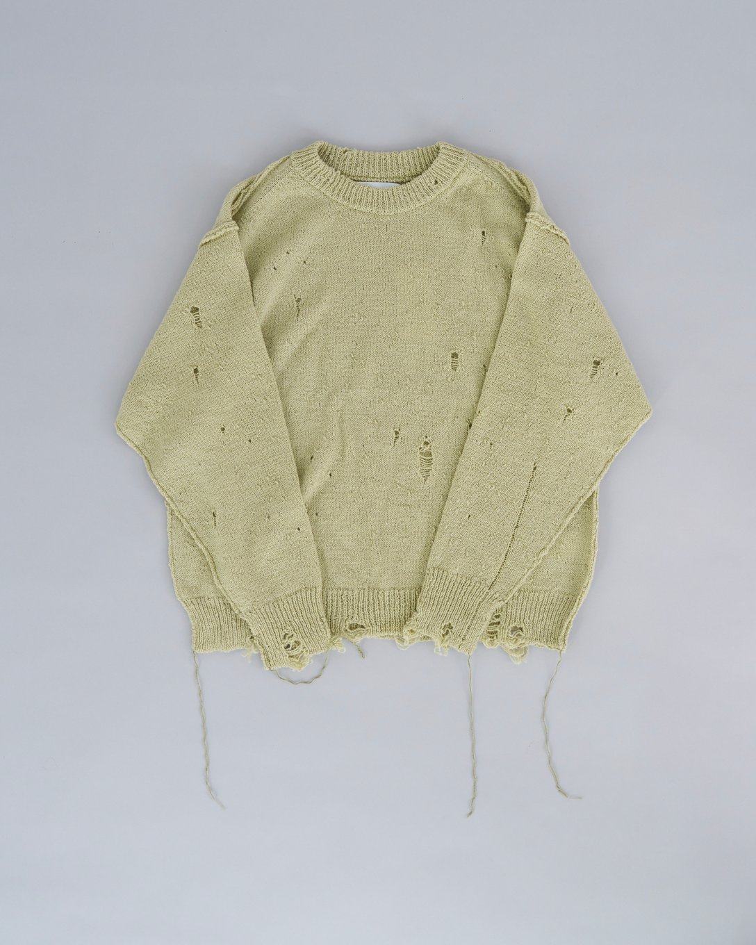イエローカラーのダメージデザインの効いたセーター