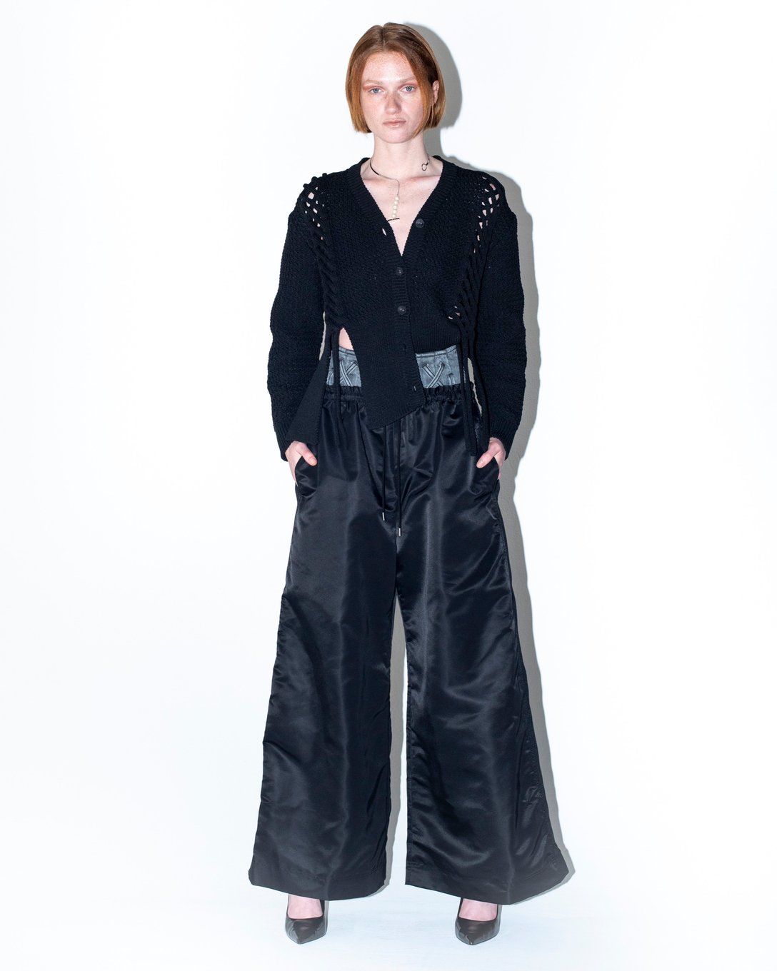 ニットカーディガンとブラックのボトムスを着用した女性のルック画像