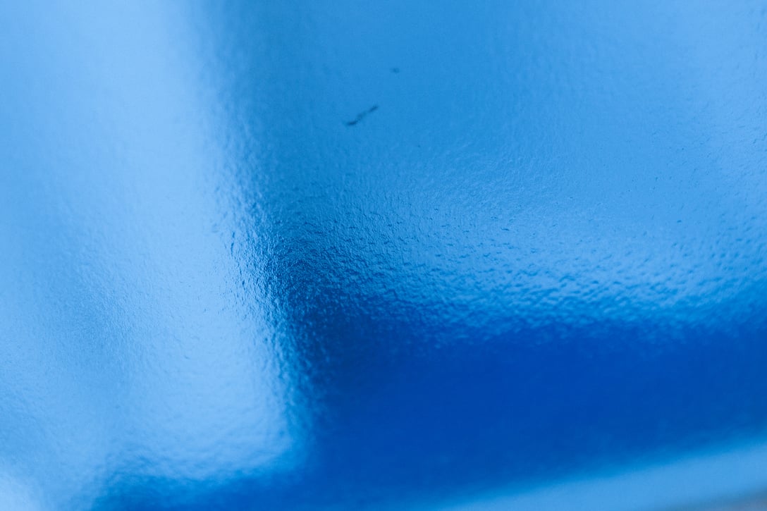 窓越しの青い床と白いカーテン