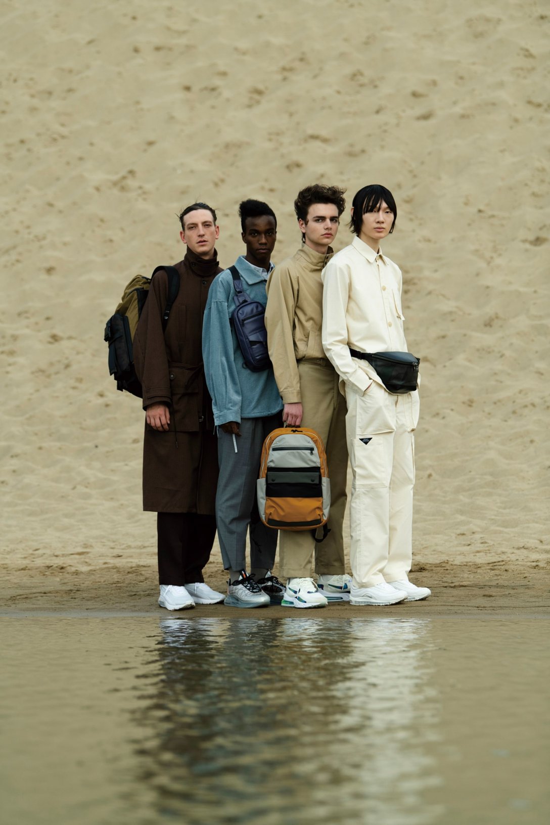 砂漠の水辺に佇む4人の男性モデル