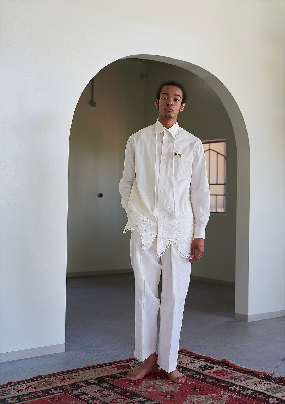 アンスクリアの白シャツを着用する男性モデル