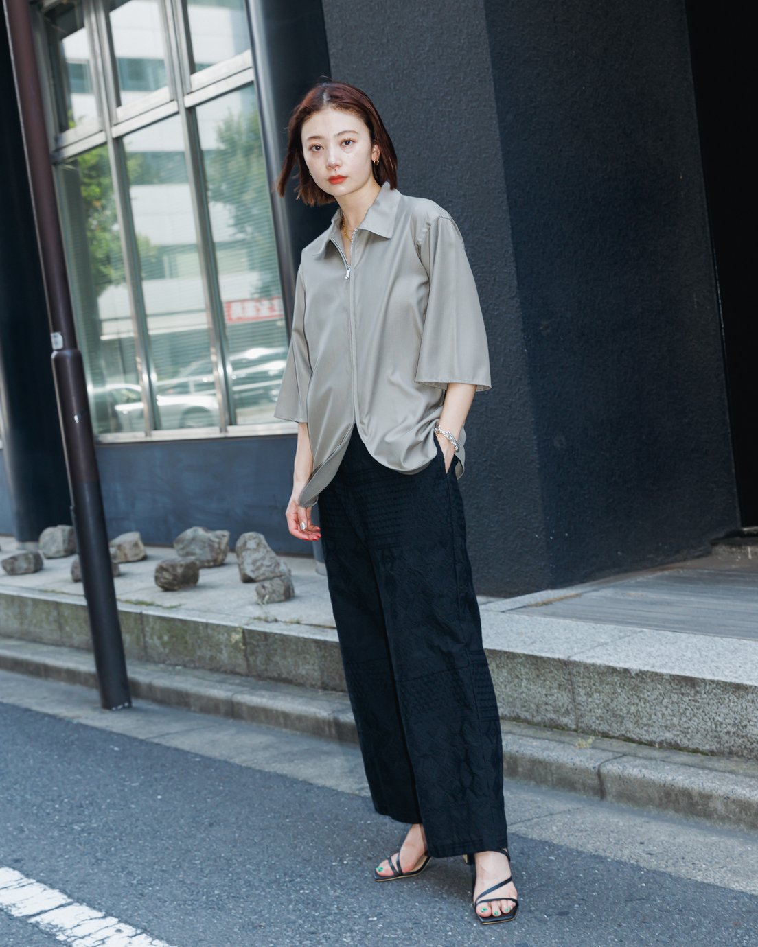 ベージュのシャツにブラックのパンツを合わせた女性モデル