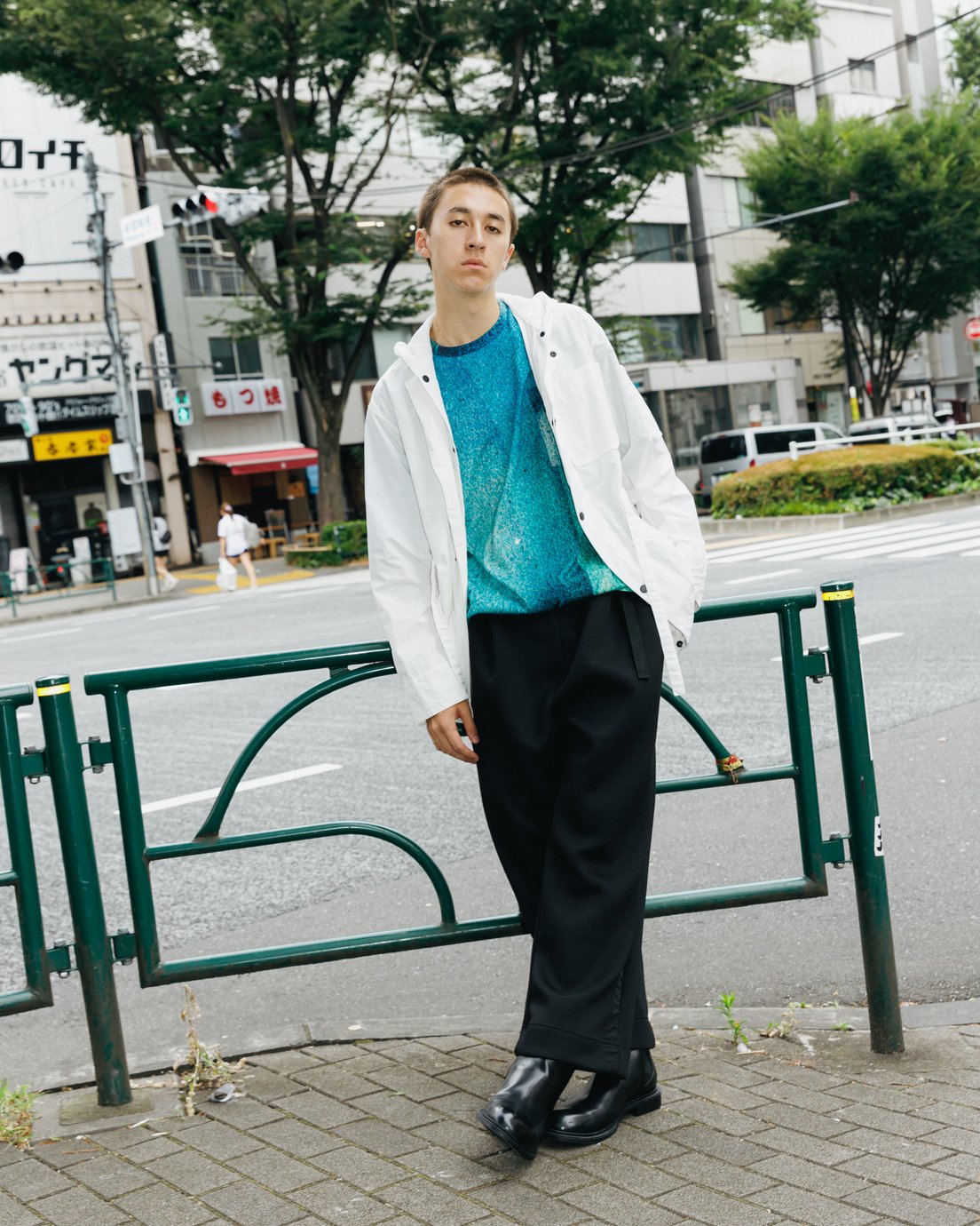 ブルーのTシャツに白のブルゾンを羽織った男性