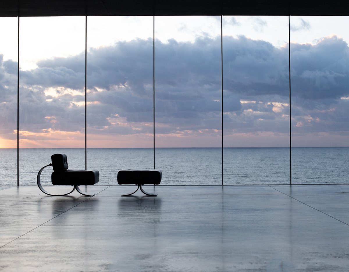 夕方の海と空と大きなガラス窓と椅子