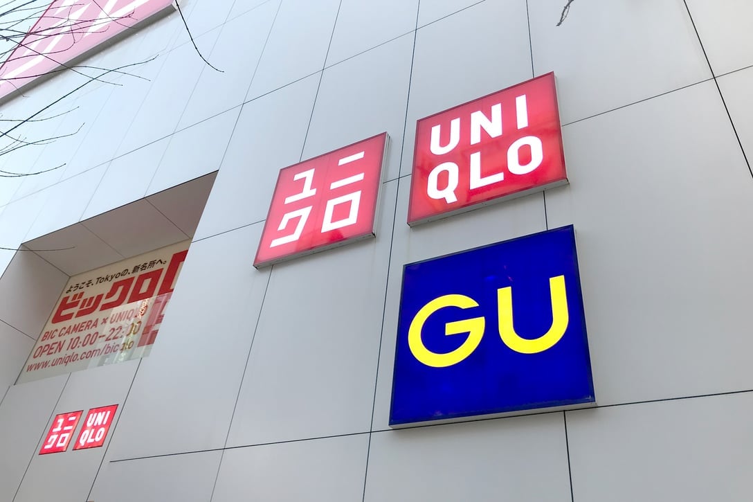 赤いユニクロの看板と青いGUの看板を設置した店舗の壁