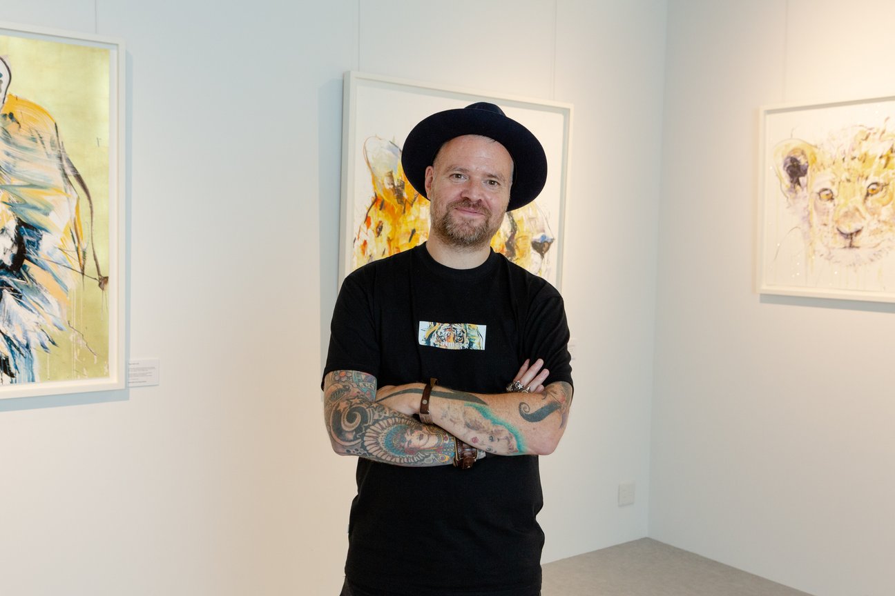 腕を組んで微笑むアーティストのデイブ・ホワイト