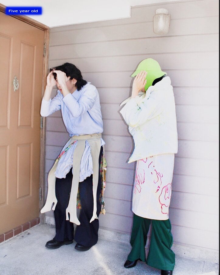 壁に並ぶ2人