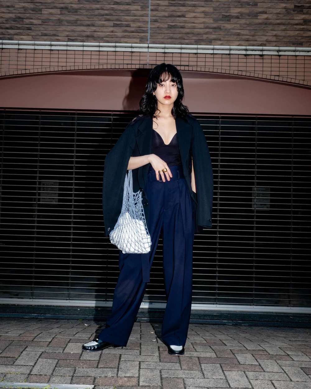 ネイビーのベルテッドパンツを履いている女性モデル