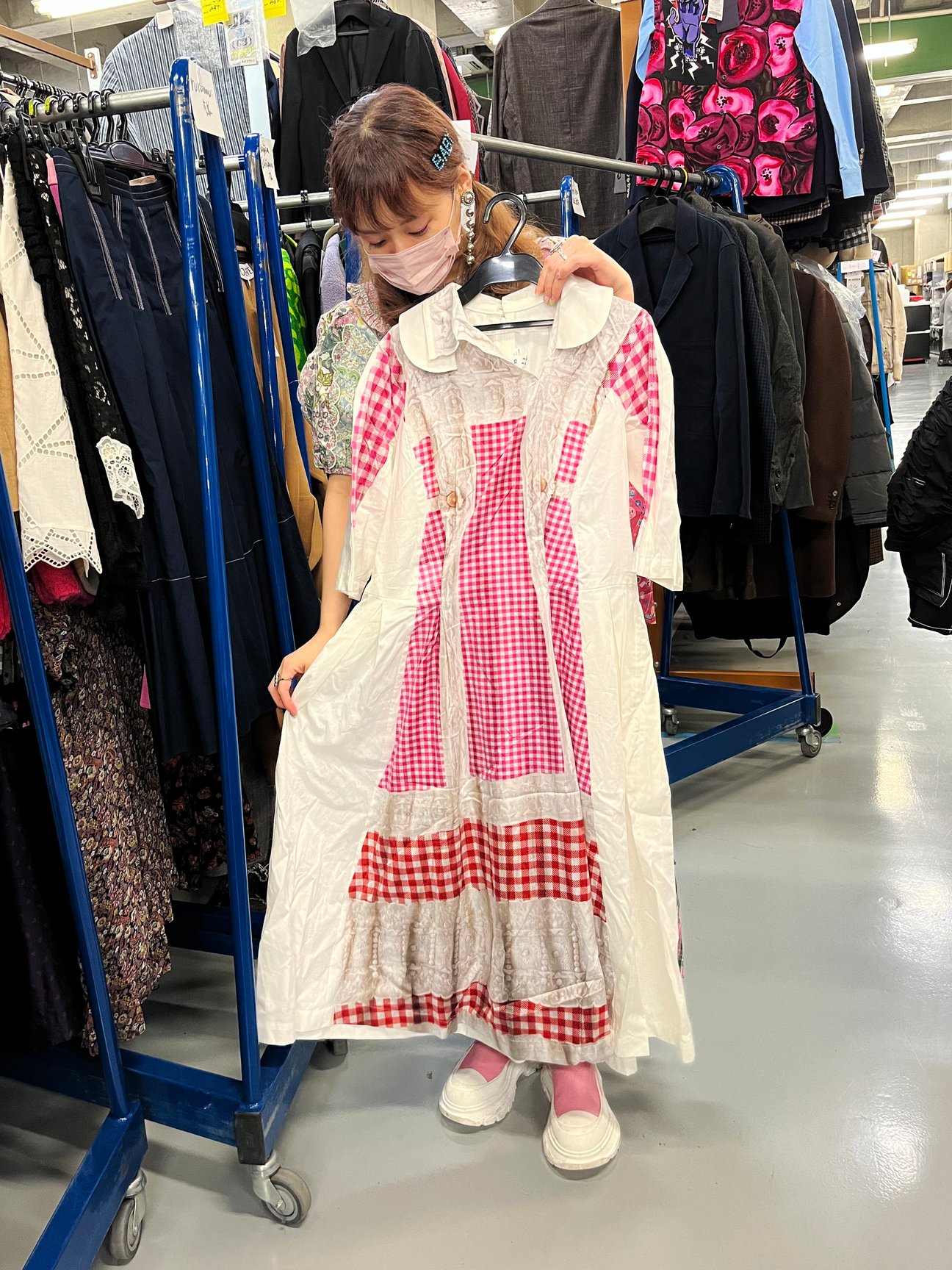 総柄ワンピースを手に持つ女性