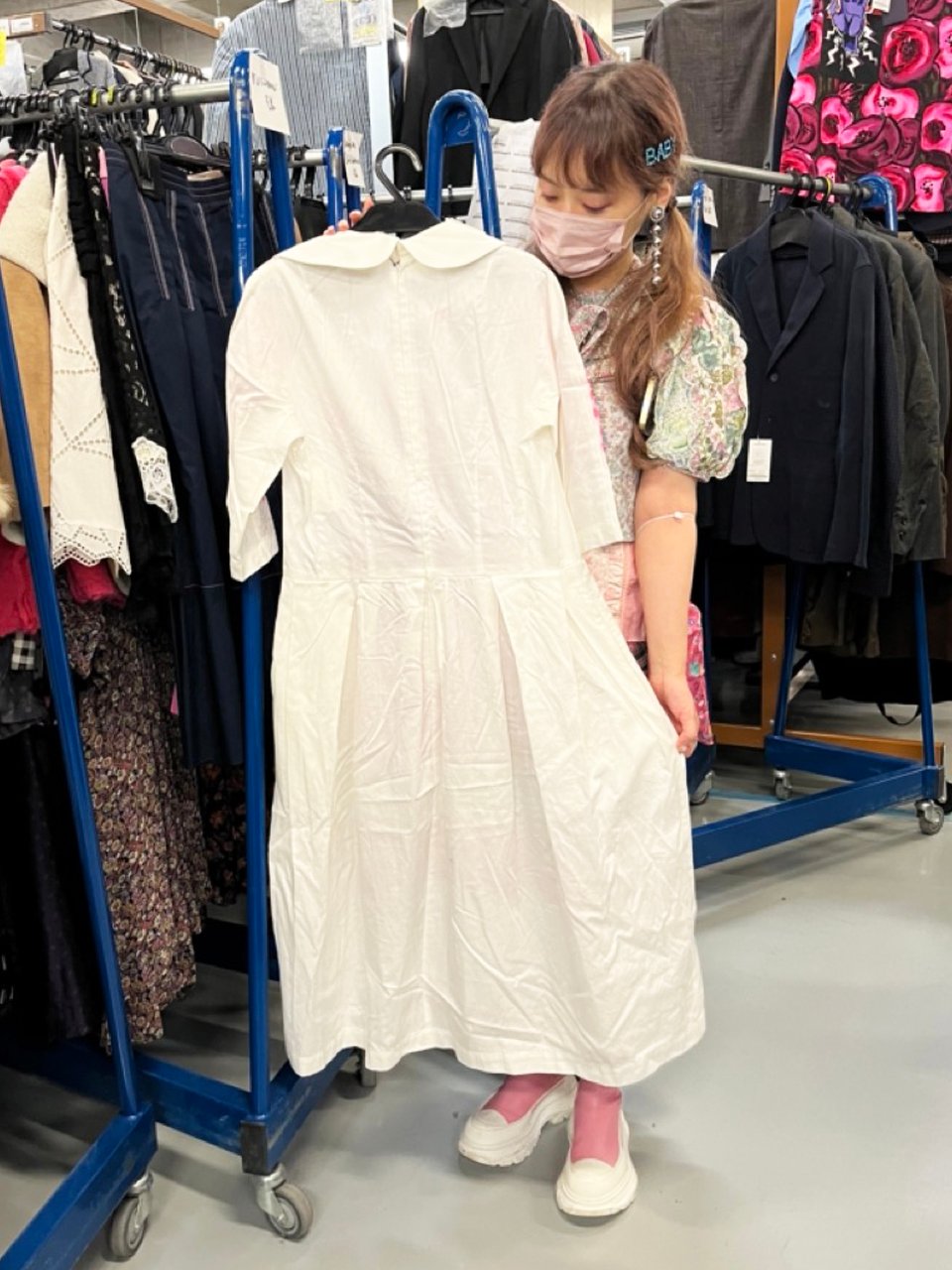 白いワンピースを手に持つ女性
