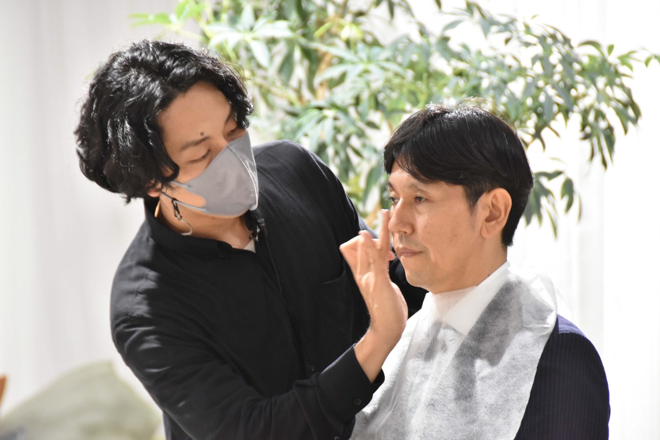 男性にメイクをするヘアメイクアーティスト
