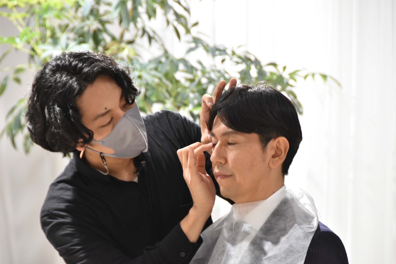 アイメイクを施す男性メイクアップアーティスト