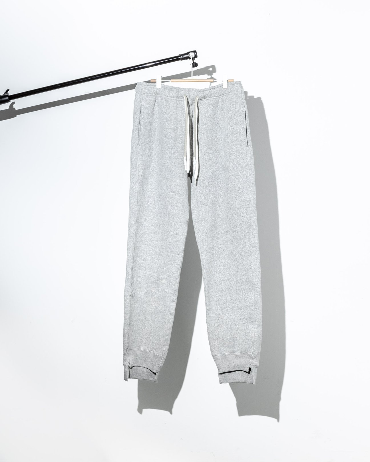 ハンガーに掛かったタナカのグレーのスウェットパンツ