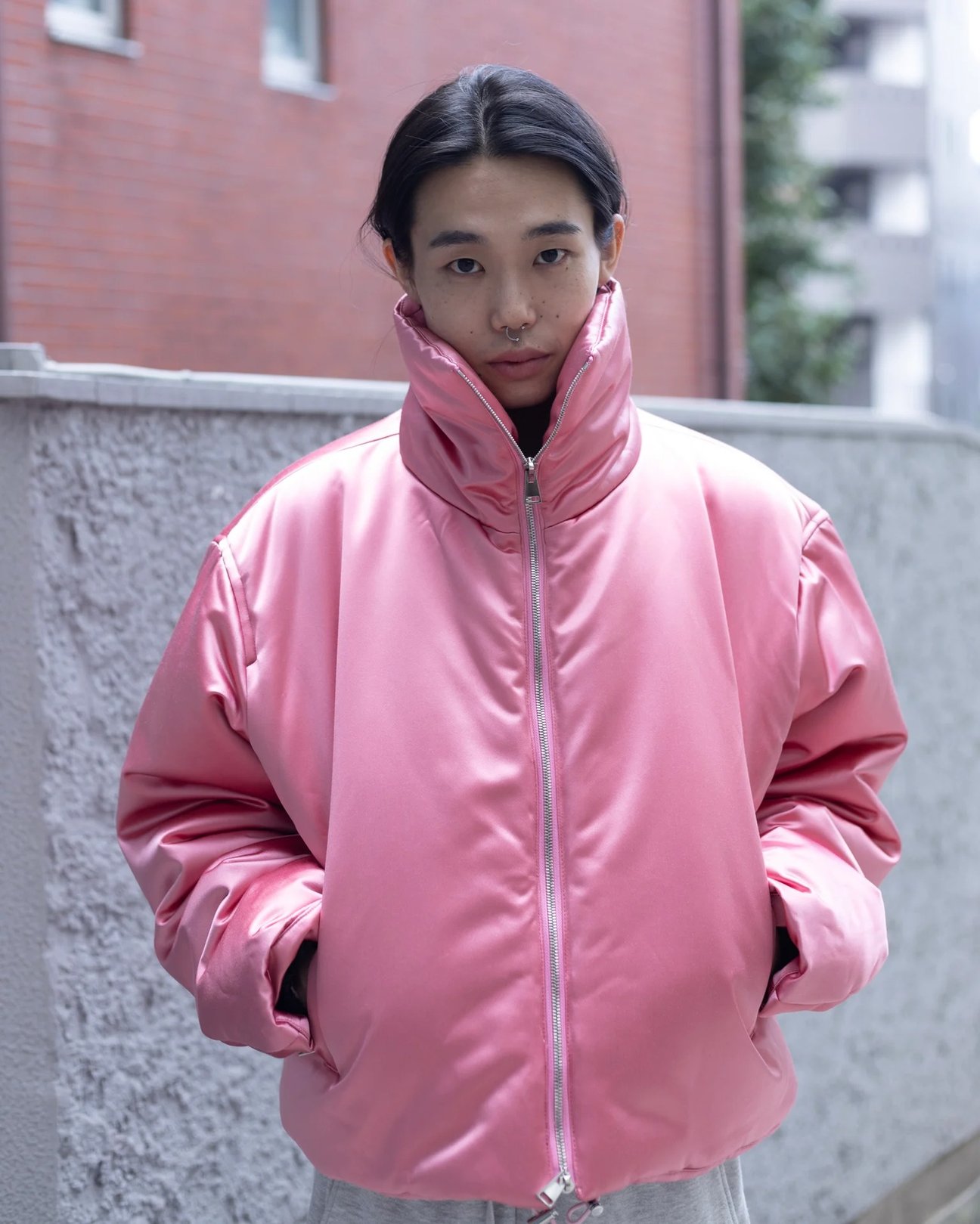 ピンクのダウンを着た男性モデルのバストアップ画像