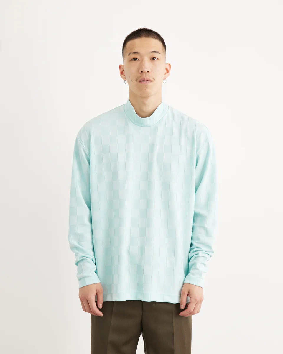 ウジョーのミントカラーのモックネックロングスリーブTシャツを着た男性モデル