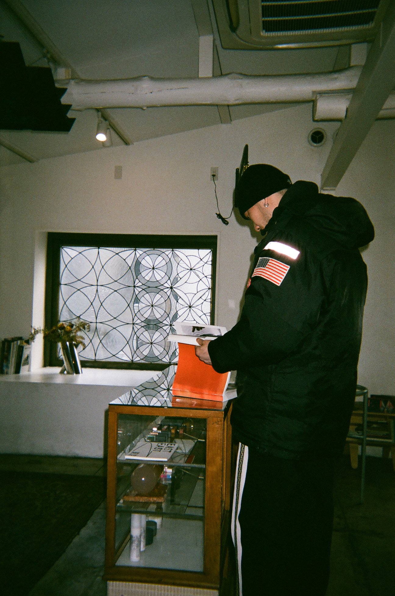 立って写真集を見ている黒い服の男性