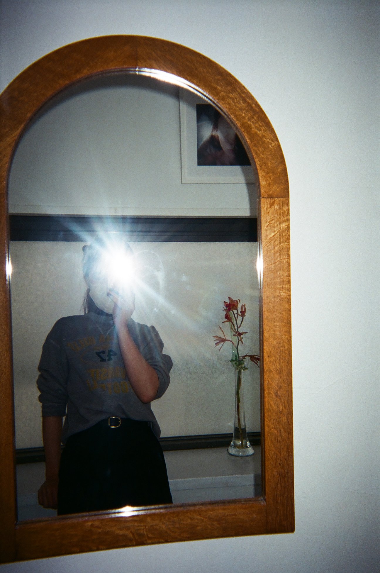 鏡越しにフラッシュを焚いて写真を撮る女性